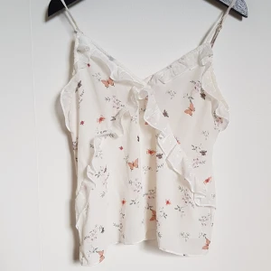 Blus H&M - En vit blus med fjärilar och blommor på från h&m. Den är ganska gebomskinglig men funkar om du har en beige bh under. Storleken är 36 men den är väldigt liten i storleken och skulle inte passa någon med större byst/bröst. Den är knappt använd och är som i nyskick. Frakt ingår i priset och du betalar via swish.