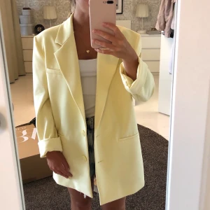 Oversized blazer  - Pastell gul oversized blazer med markerade axlar från Zara. Köpt för två år sedan för 700kr men aldrig använd då jag är alldeles för petit för den.                                               Blazern är i storlek XS men då den är oversized skulle jag säga att den passar upp till storlek M.                                                         (Hade från början axelvaddar som kan ses på modellen på sista bilden men dessa har tagits ut.)
