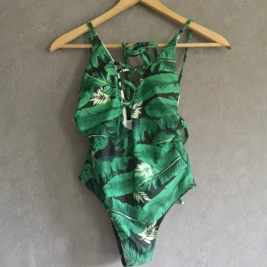 Djungel baddräkt ☀️ - Helt ny och oanvänd baddräkt, med vadderade kupor och snörning bak. Storlek S, True to size. L 60cm. B 33cmx2 men såklart mycket elastisk.  130kr pp 44kr