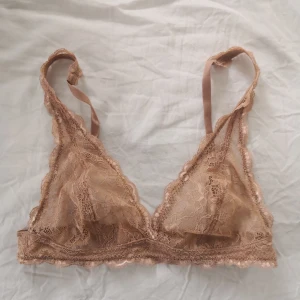 Bralette "Lonnie" från Monki - Fin bralette i beige spets från Monki, endast använd 1 gång, säljs då den inte passar. Storlek är S, lappen är dock borttagen. Bild 2 är samma modell men annan färg. Skick som ny! 