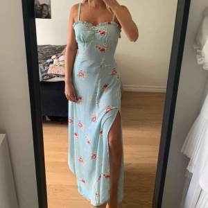 Ljusblå/mintgrön långklänning - Superfin ljusblå/mintgrön långklänning från bikbok! Storlek XS, aldrig använd. Dragkedja i ryggen & knytbart band vid ryggen för att framhäva midjan! Slits på varsin sida om klänningen & sömmar för att framhäva bysten! Frakt ingår!