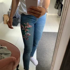 Zarajeans med blommor - Somriga jeans från zara med målade blommor på, men som tyvärr inte längre kommer till användning. Färgen är mest som på första bilden och de är i storlek 36, men väldigt stretchiga så passar även en 34.