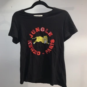 Kenzo x H&M t-shirt - Svart t-shirt från H&M’s kollektion med Kenzo, i storlek M men sitter snyggt på både S och M beroende på hur man vill att den ska sitta🌺