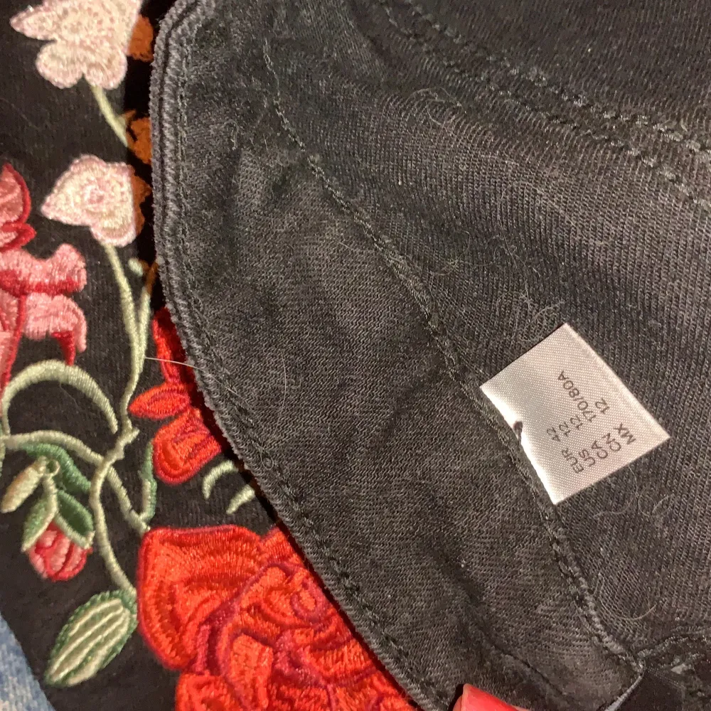 Oanvända svarta jeans från H&M med broderade rosor på. Aldrig använda då de är för korta och för små :( Står stl 42 men tycker de borde passa 38/40. Jeans & Byxor.
