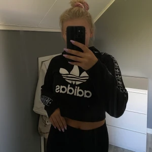 Adidas hoodie - Croppad hoodie från adidas, inte klippt själv utan den är gjord så. Feta detaljer på ärmarna!!! 