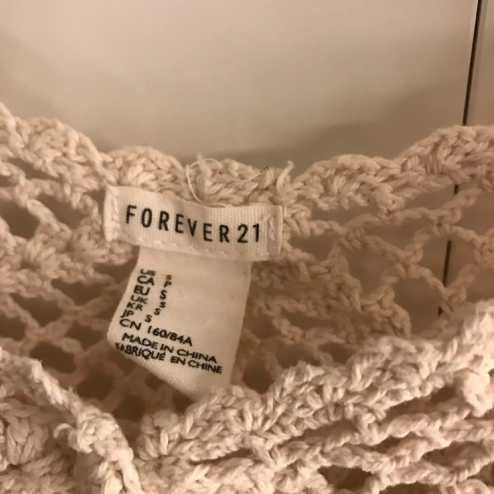 Supergulligt virkat linne i benvitt/beige från Forever 21. Strl small men passar en medium också. Sparsamt använd. . Toppar.