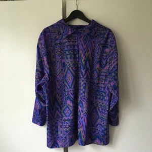  - Snygg, tunn skjorta i sportmaterial-ish. Bra skick och jättesnygga, starka färger i Aztec-mönster! Funkar som oversize! Dock för stor i kragen för mig som bär S/M... Denna kan man antingen bära som skjorta med byxor eller klänning beroende på hur lång man är!  Väldigt 90-tal! Köpt på secondhand!   Köparen står för frakten! Betalningen sker via swish!
