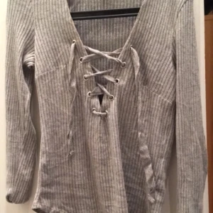  - Fin grå ribbad tröja med snörning vid brösten 