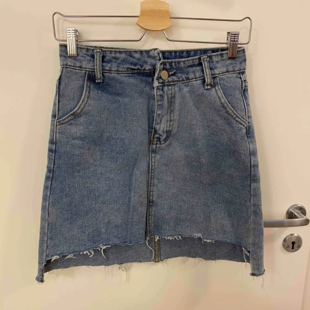 Hip jeanskjol med fickor både fram o baktill. Dragkedja samt knapp som öppning. Kjolen är lite längre baktill än framdelen. Köpt på utländsk sida så står L men är SMALL. Kjolar.