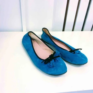  - Söta ballerinaskor i färgglad blå nyans, utsmyckad med små tofsar snörade i svart rosett. (Finns i Rissne. Swish-betalning/köparen står för frakten.)