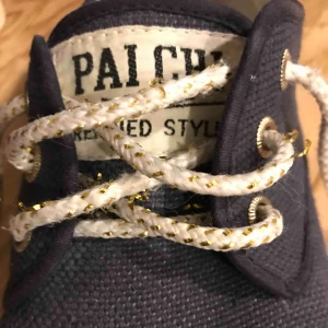  - Unika söta skor i textil med liten platå. Fint skick. Skosnören i vitt och guld Marinblå  Möts upp i centrala Stockholm efter överenskommelse alt. frakt (köpte betalar fraktkostnaden, ca 70 kr)