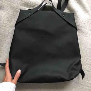 Gorgeous Rains backpack! Matte black, rubber feel. I only wore a couple times and then had to get a bigger bag that could fit all my yoga stuff :) There is a small rip inside lining of the back, but doesn’t affect the functionality. 