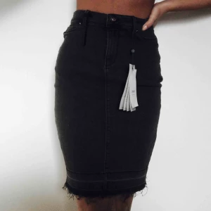  - Supersnygg jeanskjol i färgen svart/grå (urtvättad vibe) med slitningar nertill och även en snygg slits i bak på kjolen. Den är i nyskick med prislappen kvar. Materialet är väldigt stretchigt och därmed bekvämt. 