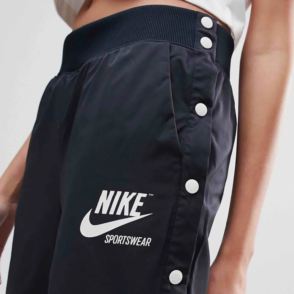 Nike - NSW Archive Snap Pant - Svart, storlek S. Aldrig använda med prislapp kvar. . Jeans & Byxor.