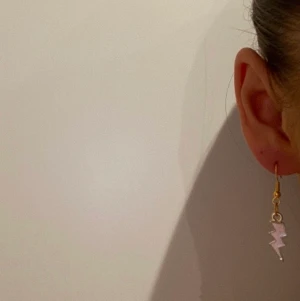 Örhänge, smycken  - X08. Jättefina örhängen i guld och rosa med blixtrar på. Glöm inte att 10% av vinsten går oavkortat till organisationen kvinna till kvinna. 