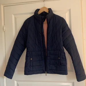 Tommy Hilfiger dunjacka  - Jättefin marinblå dunjacka från Tommy Hilfiger i storlek 176, skulle säga att det passar XS - möjligtvis S. Två fickor med knappar i fram. Fodrad med rosa färg inuti. Inga defekter, säljer för 100kr. 