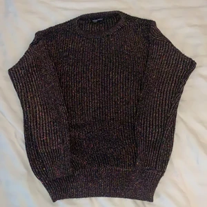 American Apparel Tröja - En stickad och glittrig tröja av märket American Apparel. Tröjan är i storlek Small och är lite loose-fitting. En mycket fin tröja, går att använda både vid festtillfällen och vardagligt. Glittret bildar dessutom olika färger.