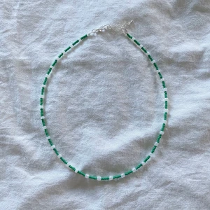 Hugo Halsband - Här är halsbandet från Hugos kollektion!! Hugos kollektion är i grönt för hans favoritfärg är grön💚 Hugo blir alltid danssugen när han lyssnar på Avicii, gillar kinderchoklad och älskar att bada🧸 20% av varje produkts vinst går till Barncancerfonden. Kolla in våra andra kollektioner!