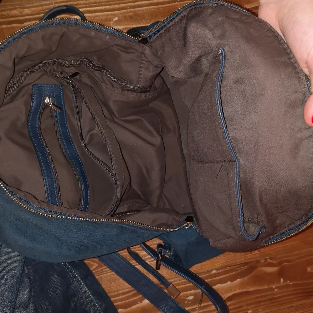 Fin och väldigt rymlig ryggsäck i mocka med 6 st fack ! Den har en del slitningar på utsidan (bild 1) från att jag har haft pins på men annars i hyfsat bra skick🌞. Väskor.