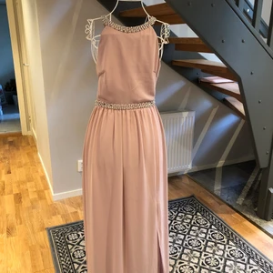 Balklänning rosa - Oanvänd balklänning i fin puderrosa färg från bubbleroom.Endast testad på grund av fel storlek. Fina stenar och pärlor på ryggen och framtill. Liten slits nertill. Storlek 12 i uk.