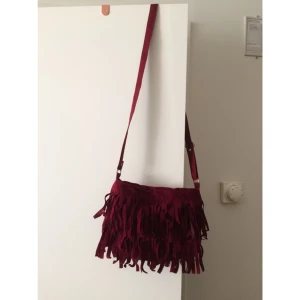  - Vinröd handväska i mockaliknande material. Aldrig använd.