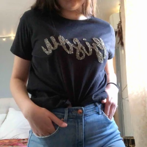 Svart t-shirt med tryck  - T-shirt med texten ”𝙱𝚒𝚜𝚘𝚞”  (kyss på franska)  knappt använd⚡️.... Kolla gärna in resten i min profil 🌎.  Pris går att diskuteras!  Köpare står för frakt  📦 (44kr) totalt - 64kr