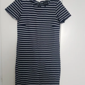 Marinblå randig klänning XS - Blåvit randig t-shirt/kortärmad klänning från Vila i storlek XS. Lite nopprig på vissa ställen, se bild 2 (går säkert att fixa med noppmaskin eller rakhyvel). 