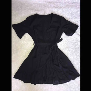  - Superfin svart sommarklänning från Nelly. I storlek 44 men passar alla eftersom man kan knyta snöret runt midjan.  Helt ny och aldrig använd, tvättad en gång därav saknas prislappen. Frakt tillkommer. 📦