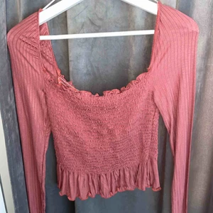  - Det här är en gammelrosa tröja med lite av resår på magen och ryggen men ”riktigt” tyg på armarna. Den här tröjan är i ett jättefint skick, aldrig använd. Den passar superbra till alla tillfällen då den inte är så tajt utan ganska stretchig i tyget.