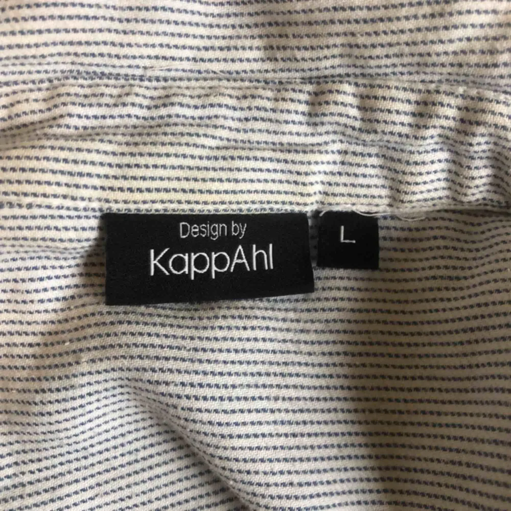 En blå och vit randig skjorta från Kappahl i storlek L men passar mig som har S om man vill ha lite oversize är den perfekt för S. Den är avklippt nedtill (se bild 3). Frakten står köparen för . Skjortor.