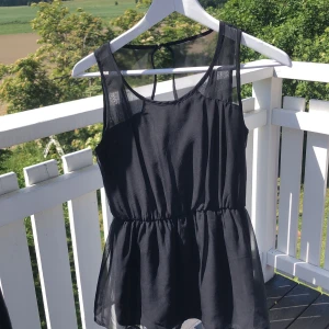 svart topp - Svart topp från VeroModa med delvis öppen rygg, och tunt tyg. Resår i midjan. Mer genomskinlig över axlarna. 