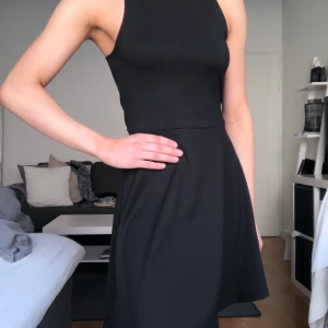 Klänning med ryggdetajl - Svart klänning i t-shirtmaterial från Gina. Alldrig använd men har klippt bort prislappen då jag trodde att den skulle komma till användning... fin detalj med öppen rygg. 