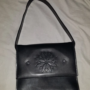 Söt svart handväska - En söt liten hand väska som skulle passa perfekt till allt, den rymmer allt man brukar ha med sig ut, telefon, nycklar, laddare o pengar. Har använd den endast 1 gång.