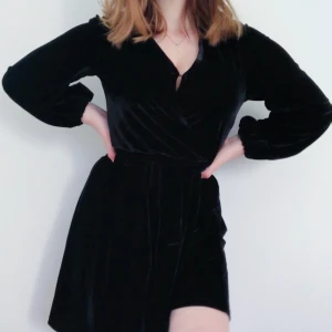 Svart Velvet klänning  - Aldrig använd Svart velour liknande klänning från Gina Tricot. Spänne vid urringningen och kan knytas i midjan, nästan som en Wrap klänning. Storlek XS men väldigt stor i storleken passar mer som en stor S eller M, jag på bilden har S.