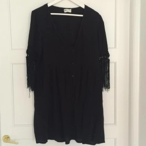  - Klänning från asos, lös modell. Fransar på ärmar, knappar framtill. Köparen står för frakt 39kr. 