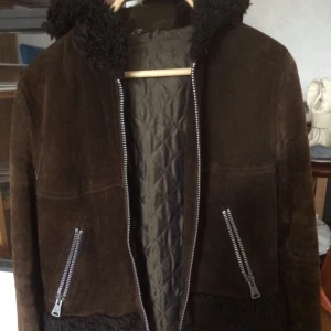  - Retro jacka i äkta mocka med ludd på armarna och luvan. Använd men i mycket fint skick då den mest hängt i gadderoben. Storlek 40 men den är rätt tajt så skulle säga 36-38. Perfekt höst och vårjacka. 