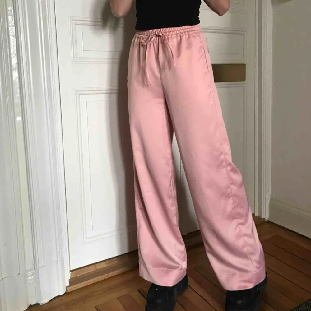 Sååååå fina rosa satinbyxor från Missguided, använda ett fåtal gånger men dom är som nya! Säljer pga inte min stil längre. Jag har sytt upp dom så det går att sprätta upp och få dem längre, jag är 170cm. Möts upp eller fraktar, köpren betalar frakt 💖💖💖. Jeans & Byxor.