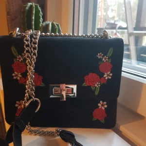  - Svårt väska med blommor på. Säljer pga att jag inte använt den någon gång sen jag köpte den förra vintern, då den inte är min stil. Köparen står för frakt om vi inte möts upp:) Går både att ha kors över och bara hengandes