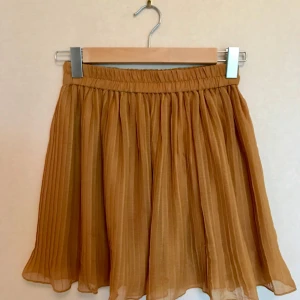  - Söt kjol från Monki i härlig höstgul färg, ordentligt band i midjan som gör att den sitter supersnyggt! Och iom dubbel lager faller den snyggt. Har använts en del men inte på sistone. Bra skick.   Frakt ingår! 