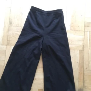  - Svarta kostymbyxor, supertighta i midjan men med utsvänga ben, fina till klackar! 