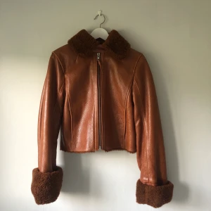 Skinnjacka H&M trend - Säljer en äkta skinnjacka från H&M trend med stor nice krage och ärmslut i fakepäls (även insidan har samma material). Jackan är kort i modellen, med två ytterfickor och är rostbrun i färgen! Storlek 34.  Använd en gång och hoppas på att hitta en ny ägare som använder den lite mer flitigt!!   Kan mötas i centrala Stockholm eller mot västerort! :-)