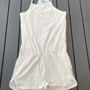 En fin vit jumpsuit med spetts från Cubus i storlek 158,164 som är ungefär som en XS. Jag har nästan aldrig använt denna så den är i fint skick. (Frakten ingår i priset)