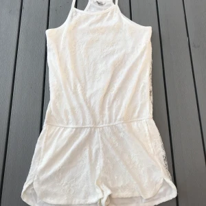 Jumpsuit i storlek 158,164 - En fin vit jumpsuit med spetts från Cubus i storlek 158,164 som är ungefär som en XS. Jag har nästan aldrig använt denna så den är i fint skick. (Frakten ingår i priset)