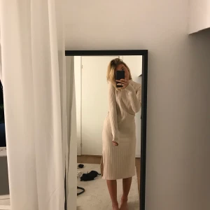 Mjuk vad-lång klänning - Jätte fin, beige, höstklänning med slits. Klänningen har slits på båda sidor. Den är aldrig använd och har lappen kvar. 