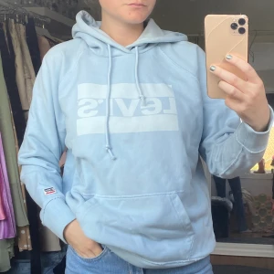 Levis Hoodie - Ljusblå Hoodie från Levis. Stolek M men passar både mindre och större då den är oversized i modellen. Använd 2 gånger är i nyskick🦋 skriv i dm vid frågor eller intresse💕