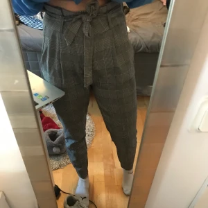 Rutiga kostymbyxor  - Perfekta kostymbyxor, sitter jättebra och är väldigt sköna. Får tyvärr inte användning för dem:( bandet kan man ta av eller byta ut till ett skärp eller bara ha utan ☺️ frakt tillkommer 