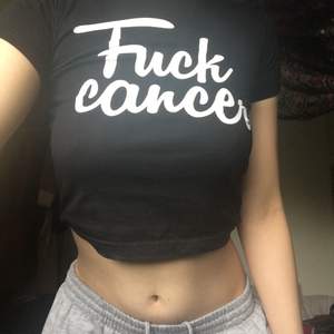 En svart babytee med text ”Fuck cancer” som funkar bra som magtröja, frakt: 22kr