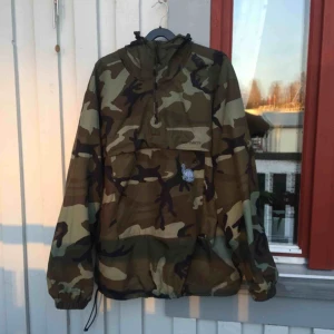  - Högst trevlig anorak-vindjacka med stor känguruficka på magen. Står att det är storlek XL men detta är högst orimligt då jag själv är 1,57 och den sitter perfekt på mig. Skulle uppskatta som Small/Medium