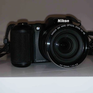  - 20-megapixelkamera. 26x optisk zoom. LCD-skärmen på 7,5 cm  18 motivtyper. Drivs av 4 AA-batterier. Linsskydd medföljer. Halsrem medföljer. USB kabel medföljer. 