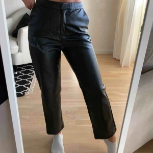 - Linn Ahlborg x NAKD. Svarta byxor i läderimitation. En dragkedja och krokstängning med en dold knappstängning. Raka ben. Endast använda 1 gång!